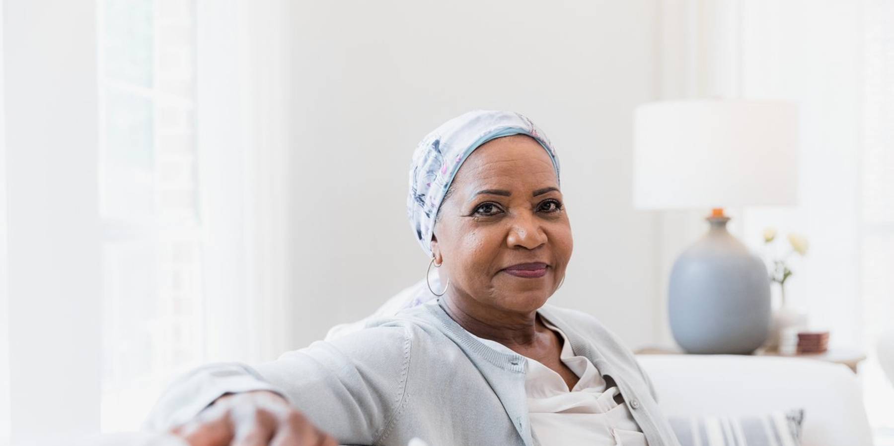 elderly woman poses for a portrait photo in her home.
