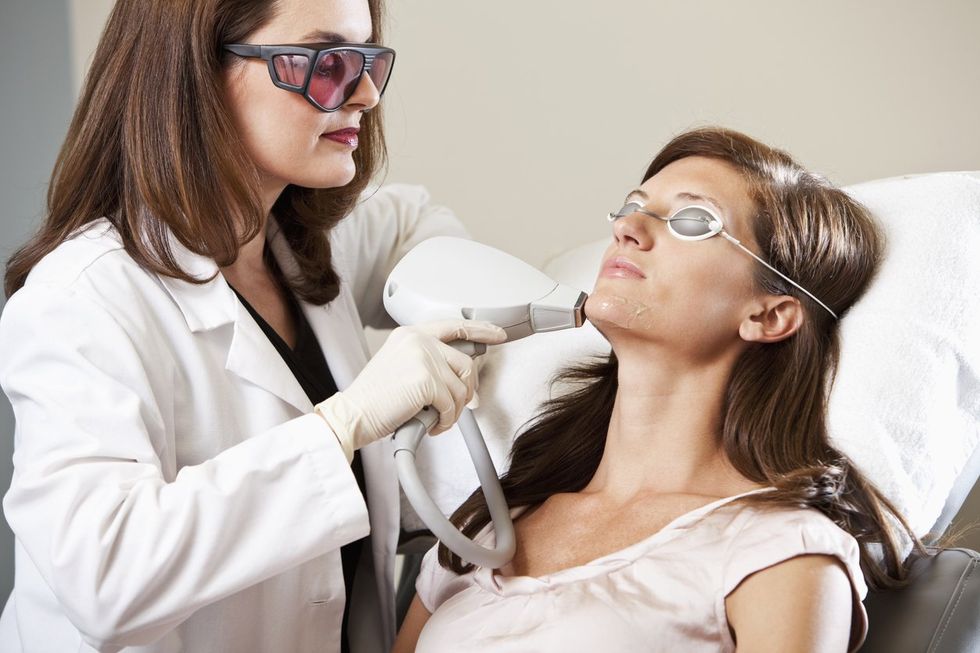 Esthetician performing laser hair removal.