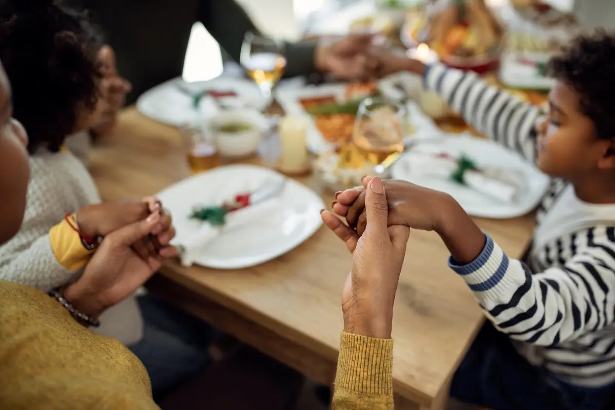 family holding hands at a holiday meal
