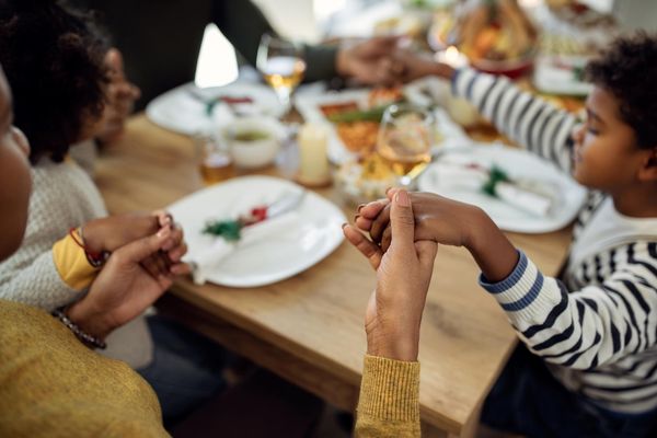 family holding hands at a holiday meal