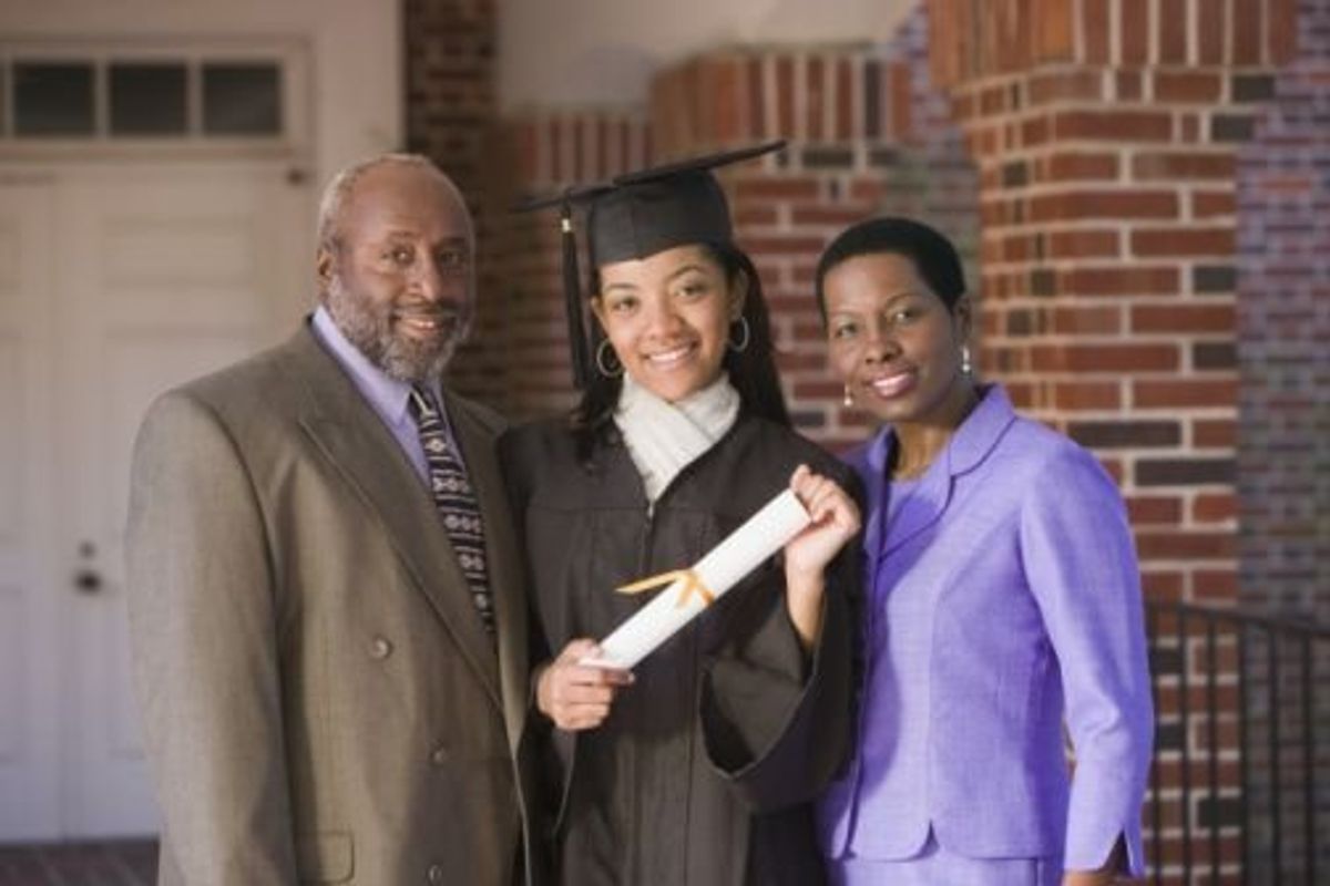 family posing with their daughter who graduated college