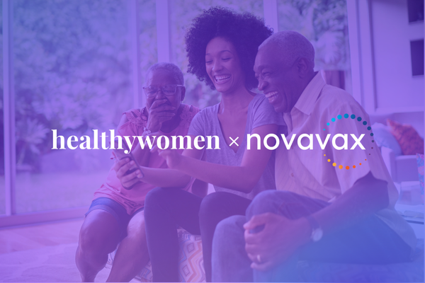 family sitting on a couch looking at a smart phone and laughing