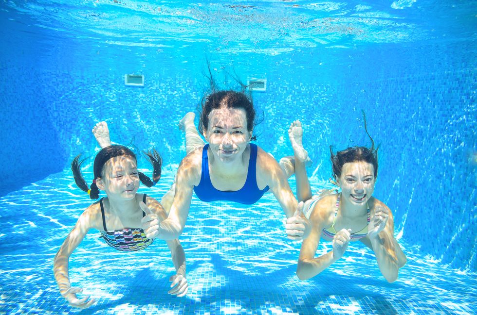 Family swim in pool underwater