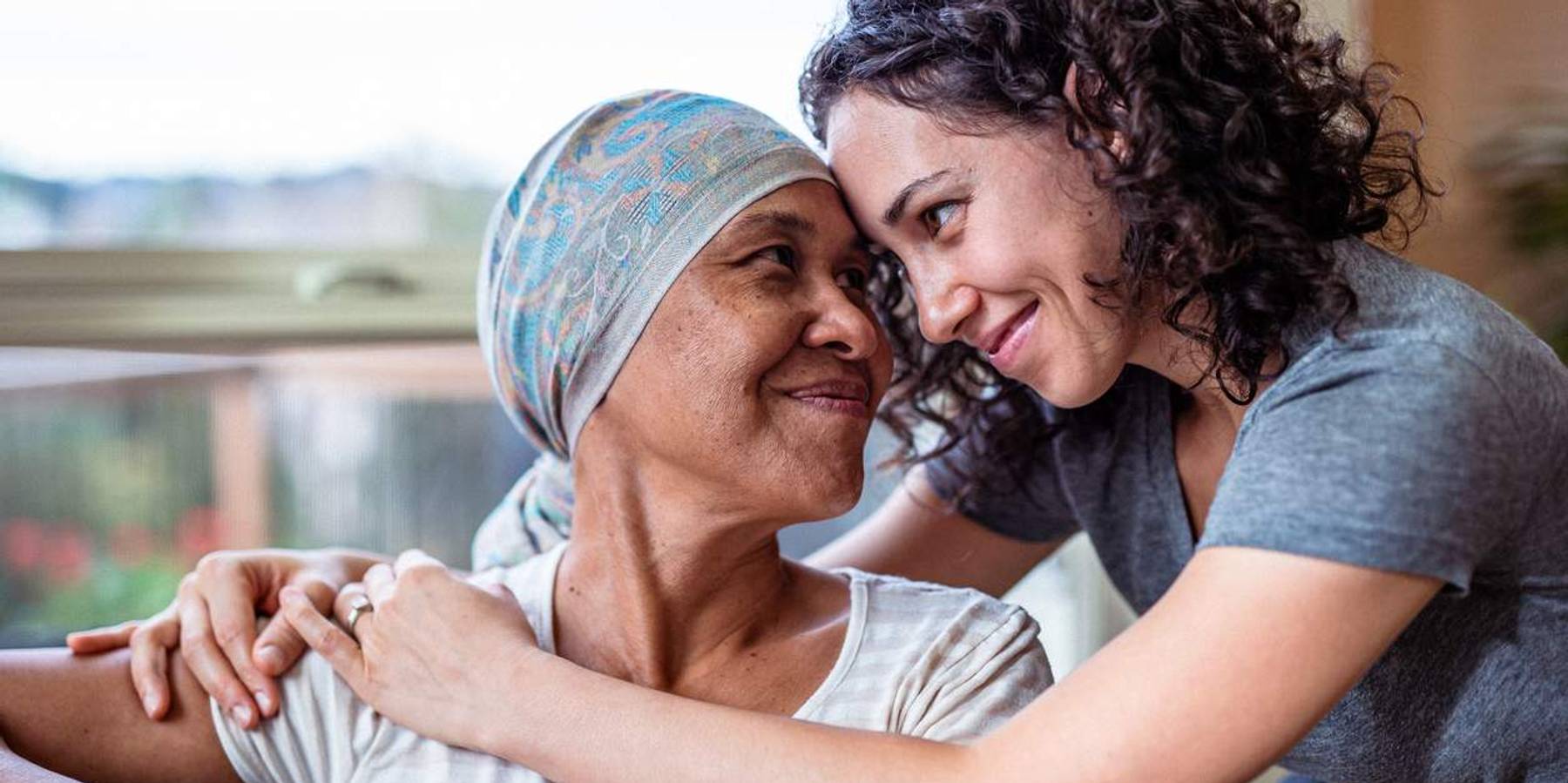 Female cancer patient hugs adult daughter
