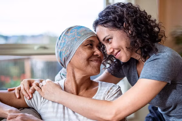 Female cancer patient hugs adult daughter