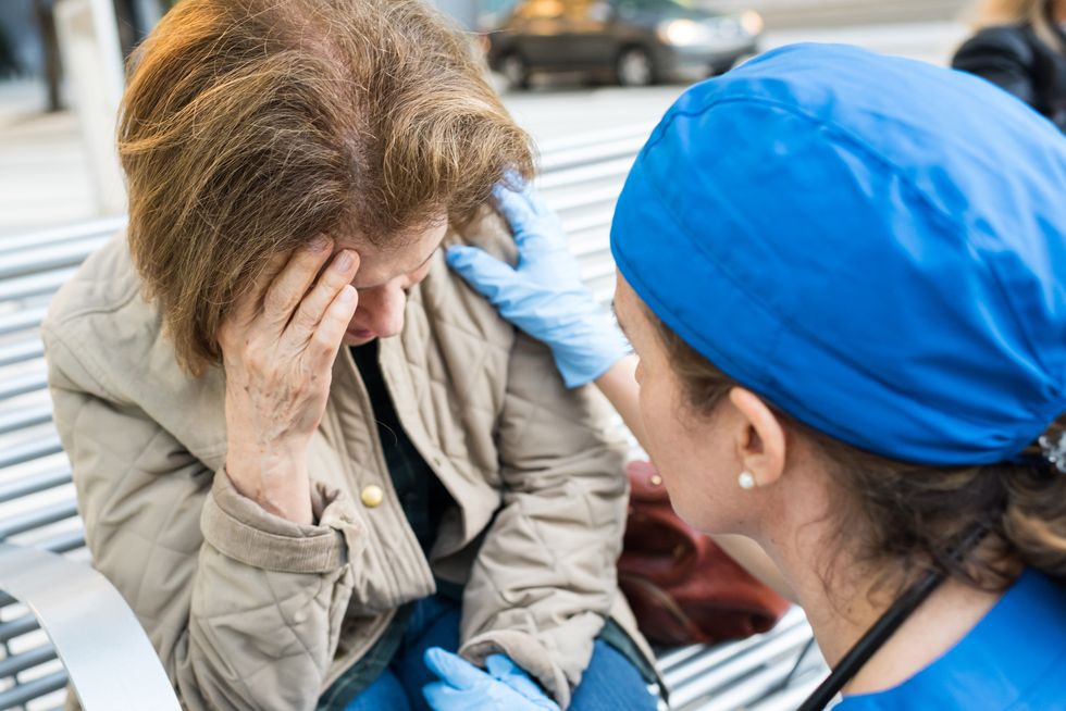 Female doctor assisting a senior woman suffering from low blood pressure