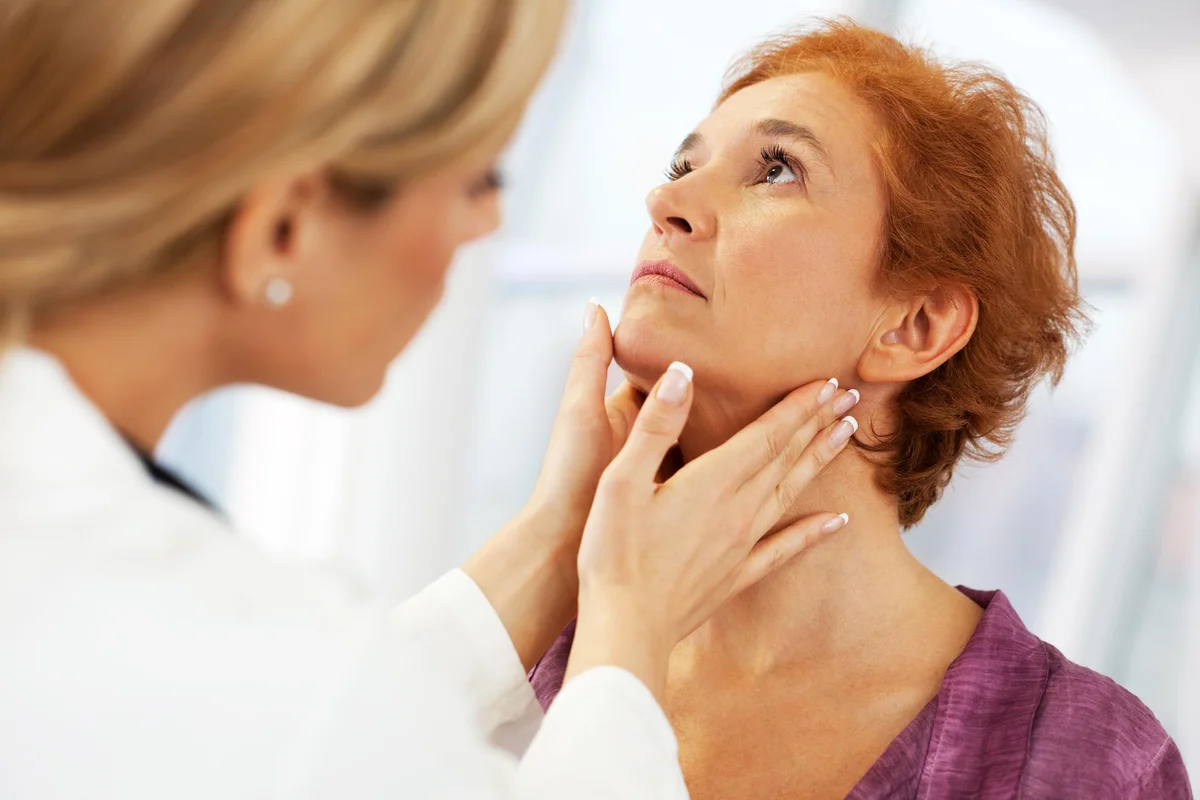 female doctor doing a medical examination on patient's Thyroid