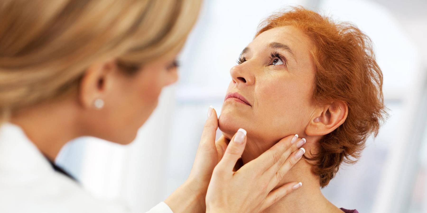 female doctor doing a medical examination on patient's Thyroid