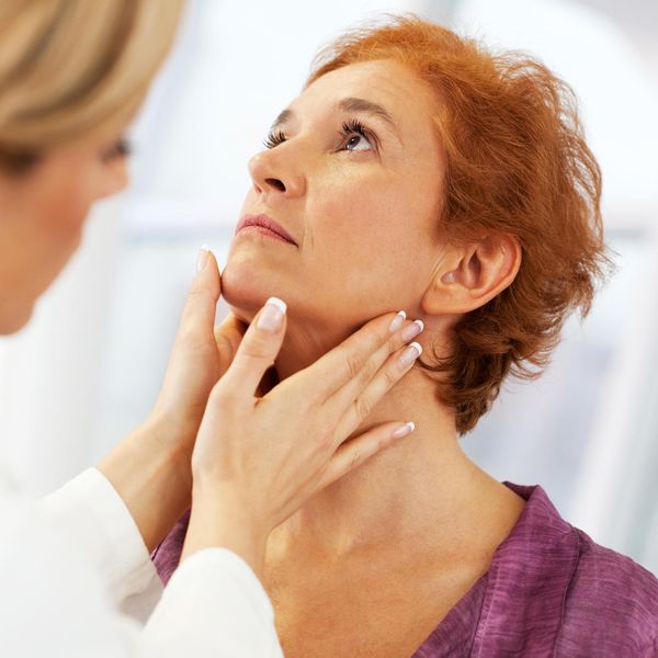 female doctor doing a medical examination on patient's Thyroid