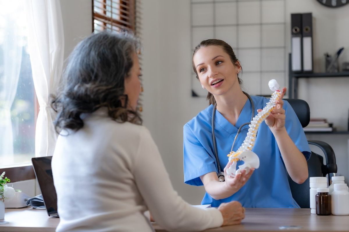 Female doctor is introducing an elderly Asian female patient about bone diseases and treatment method and medicine details.