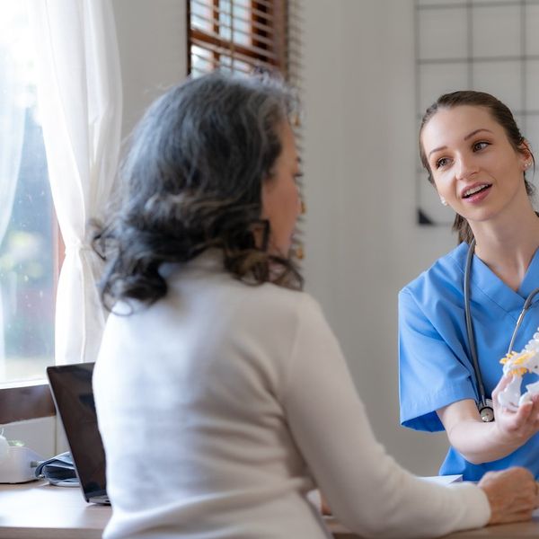 Female doctor is introducing an elderly Asian female patient about bone diseases and treatment method and medicine details.