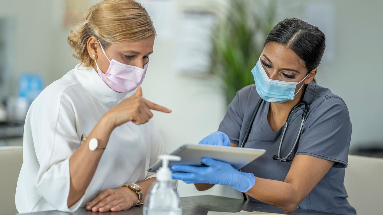 Female doctor speaking with patient wearing masks discussing a Hysterectomy