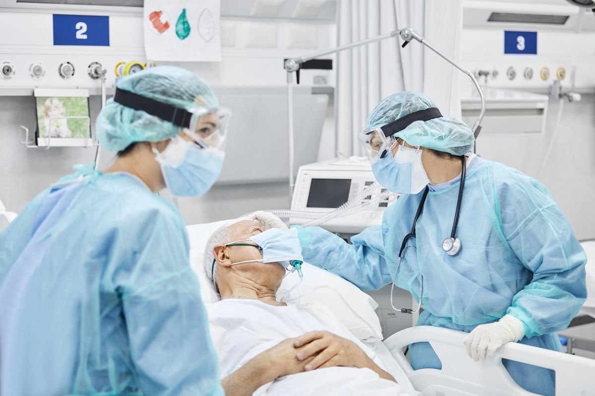 Female Doctor Talking With Patient Along Coworker