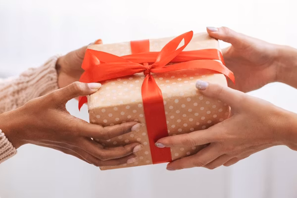 Female hands holding and giving present to woman