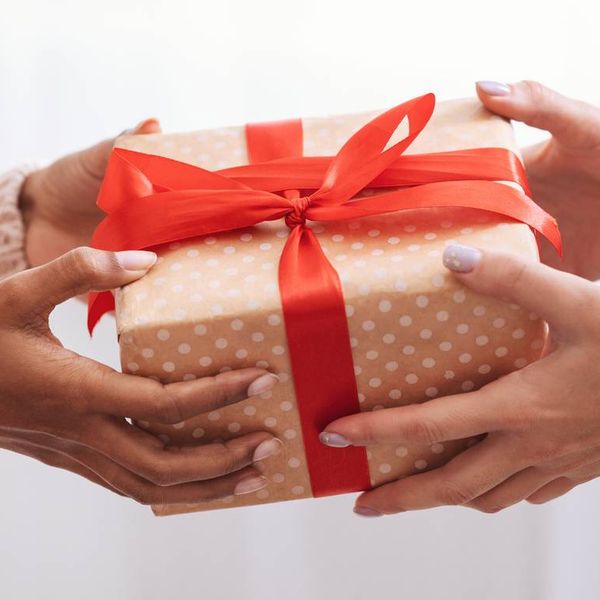 Female hands holding and giving present to woman