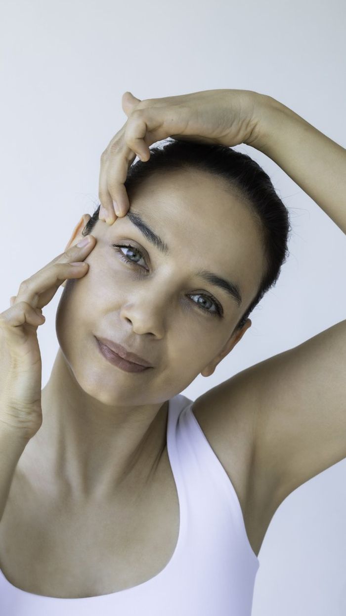female is doing face yoga gymnastics for non-surgical rejuvenation