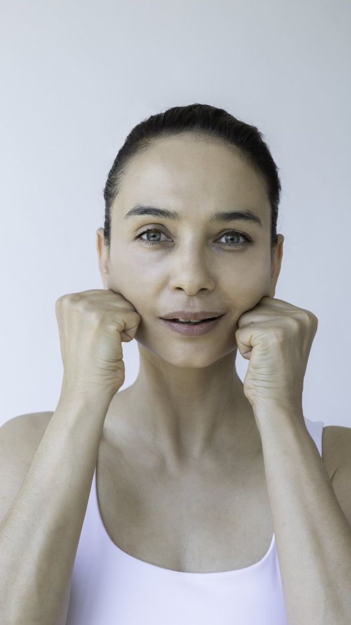 female is doing face yoga gymnastics for non-surgical rejuvenation