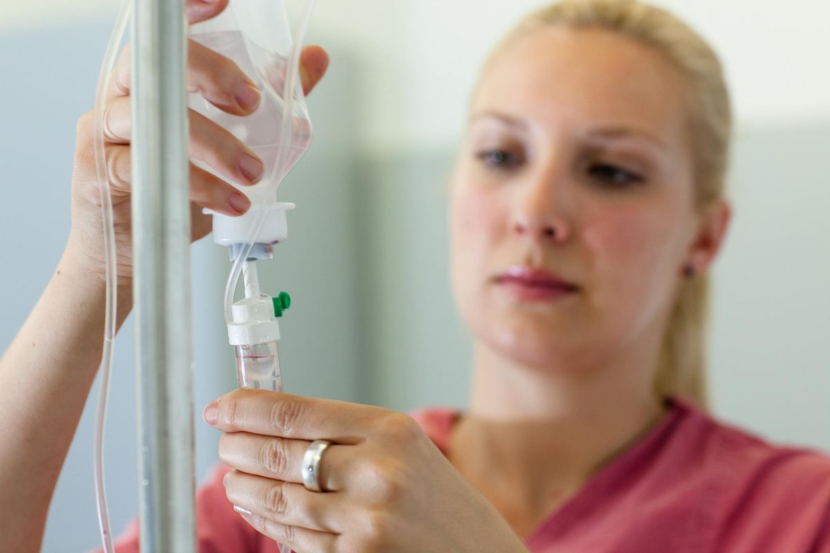 female nurse prepares an IV Drip