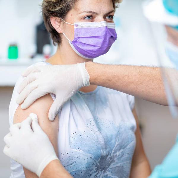 Female patient's arm disinfected with cotton pad for vaccination