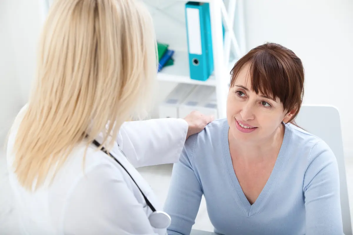Female patient with Sjögren’s disease being reassured by doctor in hospital.