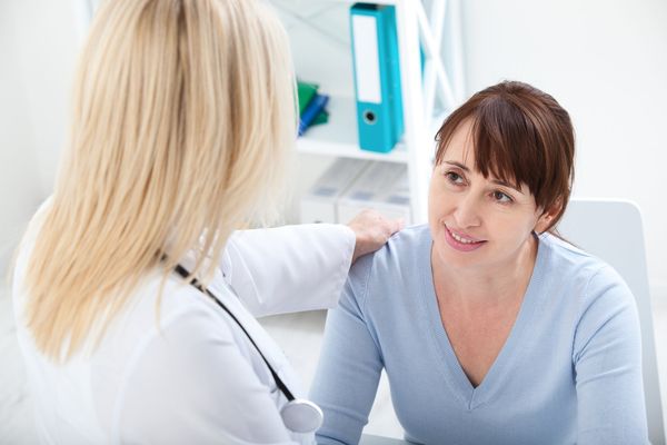 Female patient with Sjögren’s disease being reassured by doctor in hospital.
