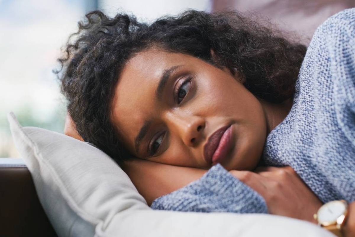 female person lying on couch with pmdd