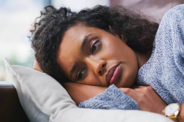 female person lying on couch with pmdd