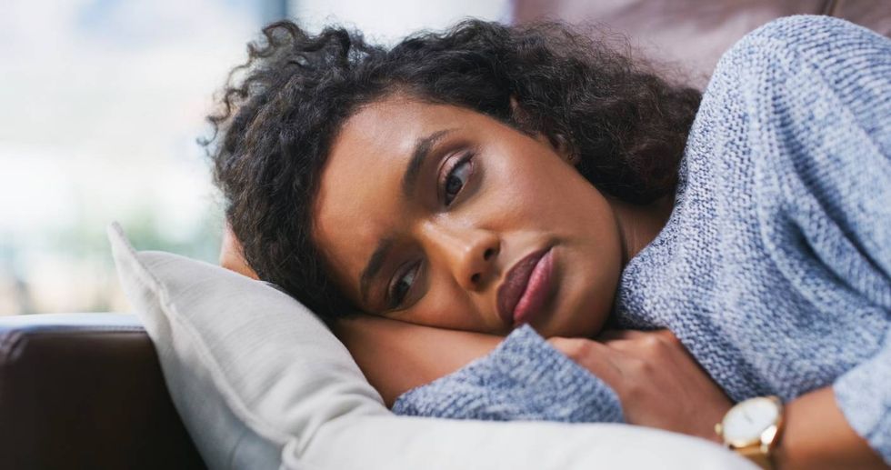 female person lying on couch with pmdd