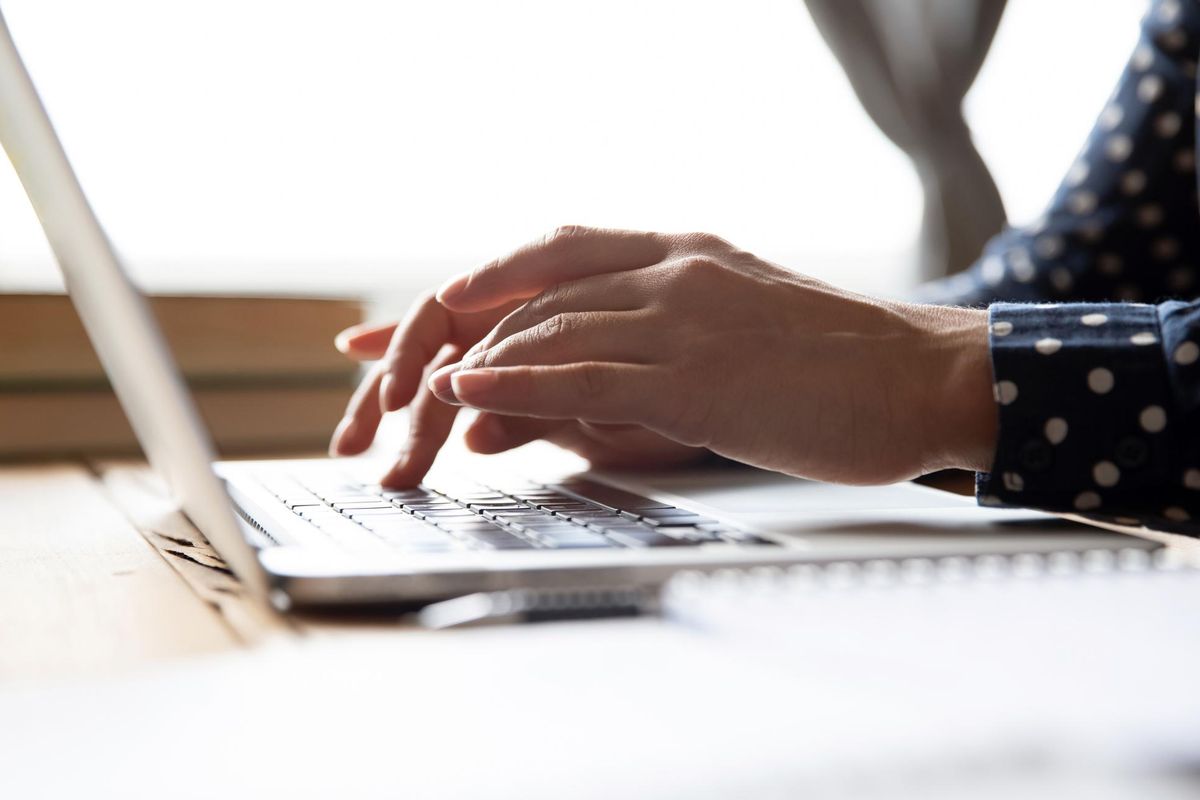 Female professional student using laptop at desk, close up view