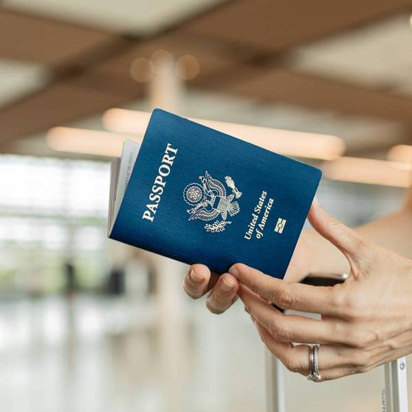 Female traveler holding USA passport at airport.