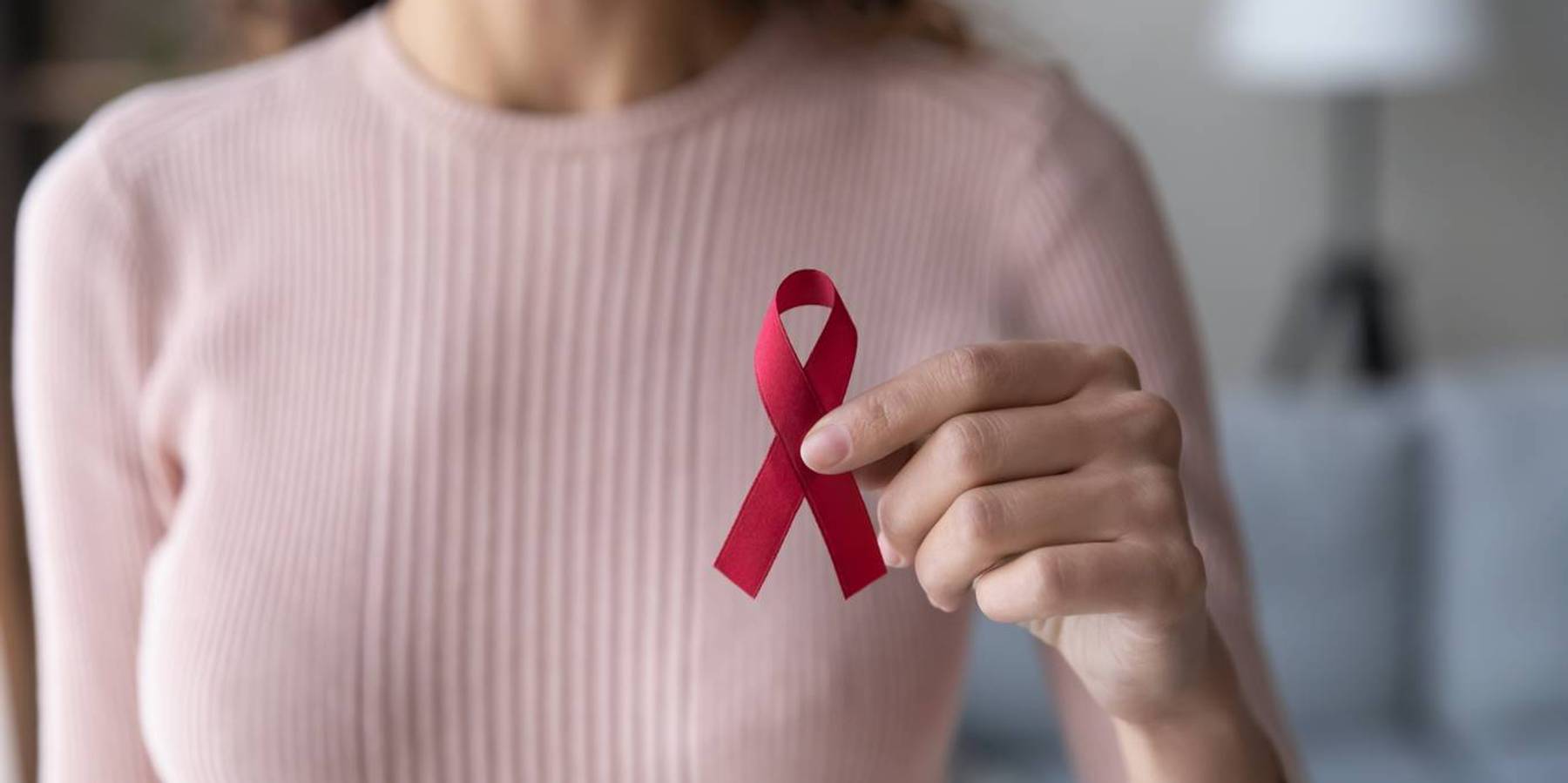 female volunteer holding red ribbon