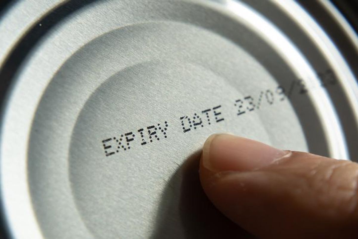 Finger pointing at the expiry date on canned food