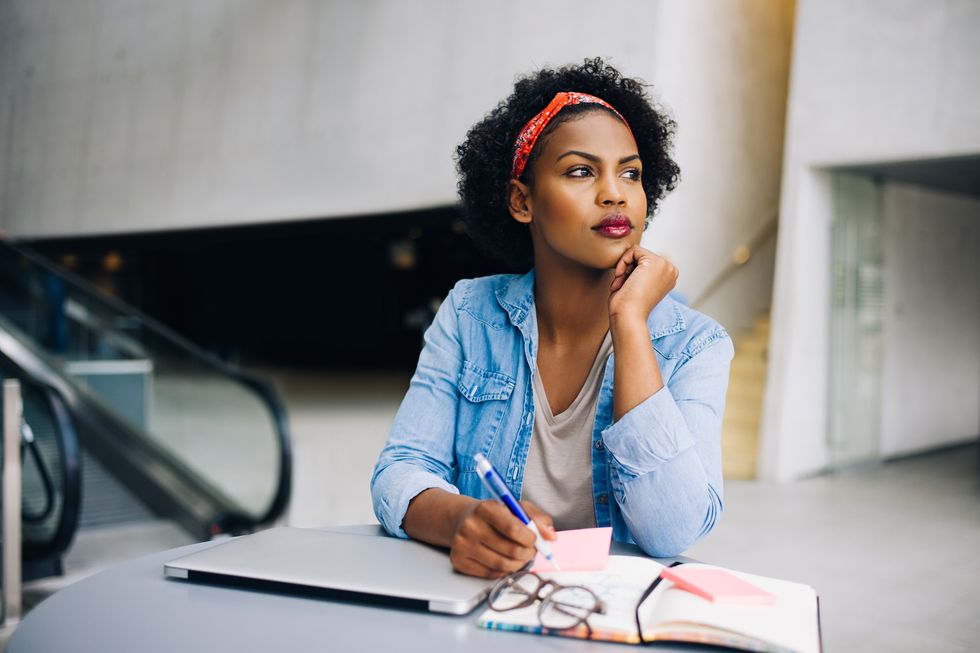 Focused young African female entrepreneur deep in thought