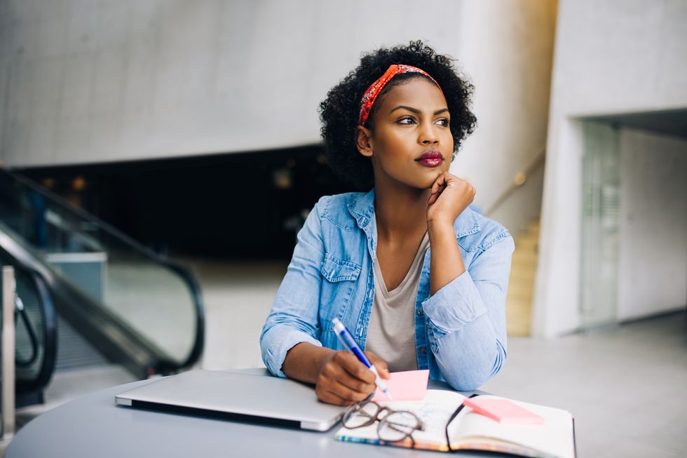 Focused young African female entrepreneur deep in thought