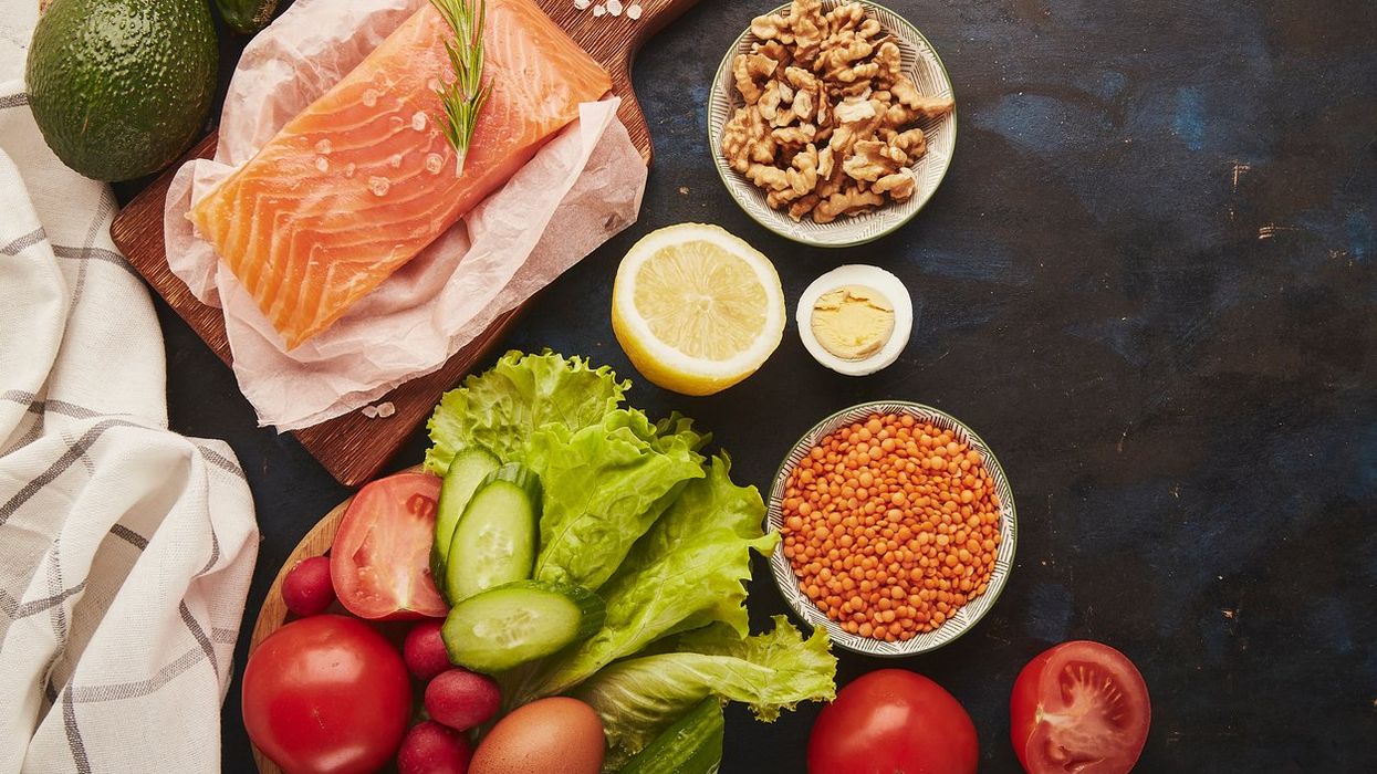 Fruits,vegetables, smoked salmon, greens on wooden black sutface FODMAP diet