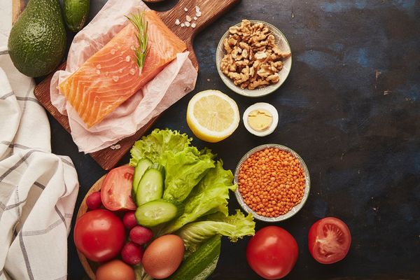 Fruits,vegetables, smoked salmon, greens on wooden black sutface FODMAP diet