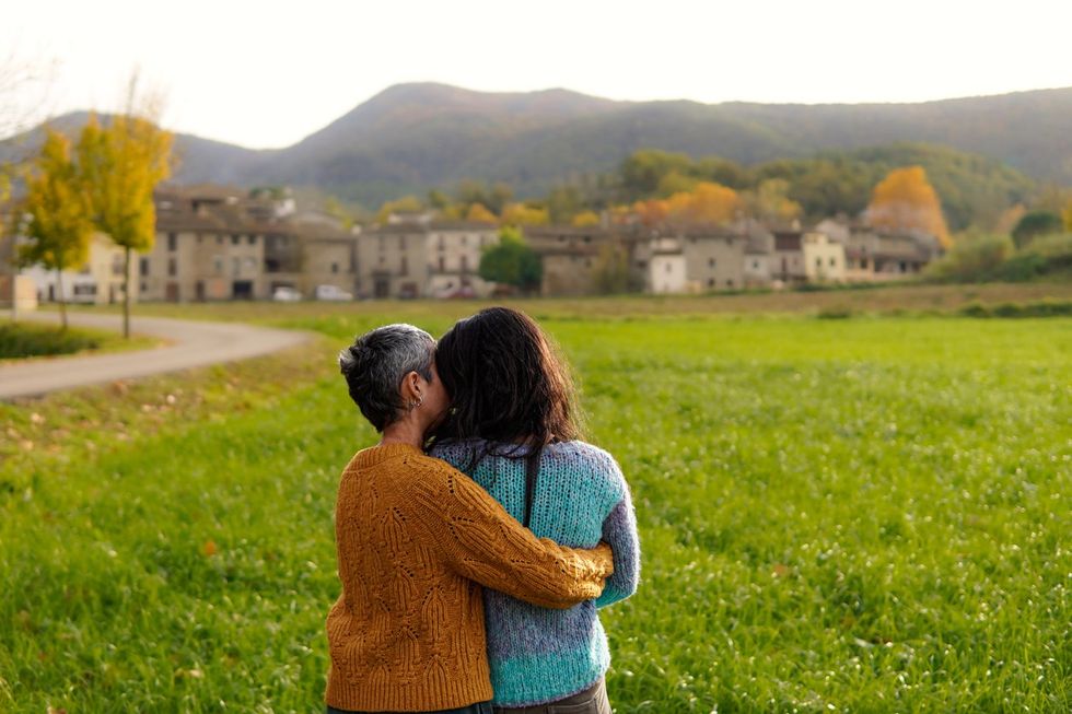 gay women couple hugging and giving affection in a Spanish rural town