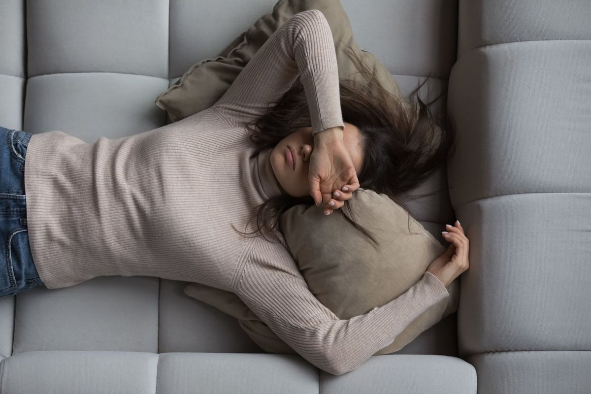 girl lying on back on comfortable couch at home