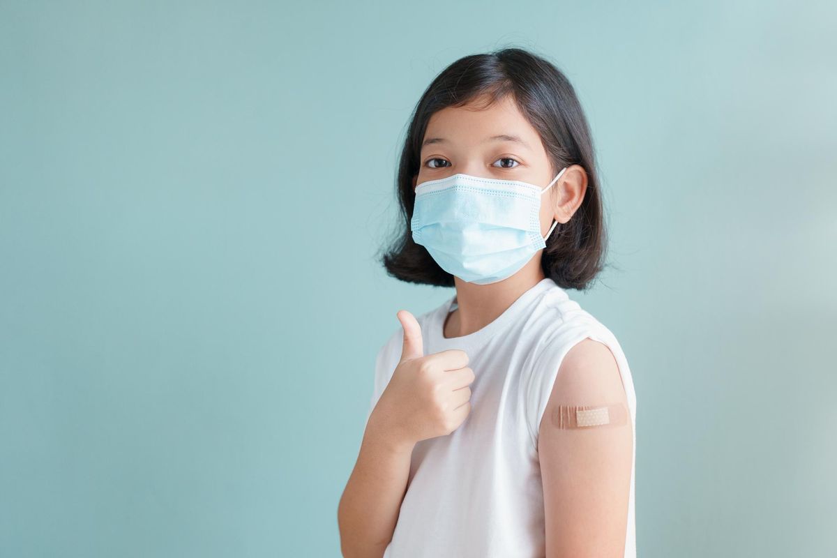 girl wearing face mask vaccinated Gesturing Thumbs Up