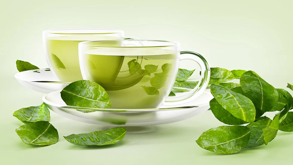 Glass cups with green tea and tea leaves