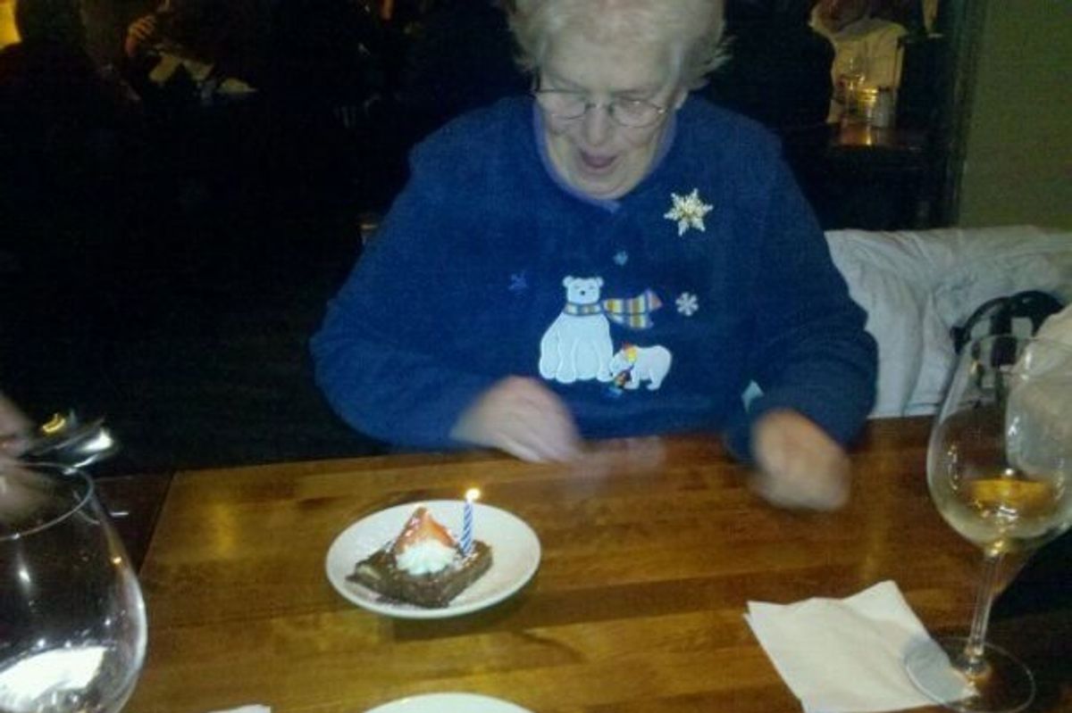 grandmother happily looking at a piece of birthday cake