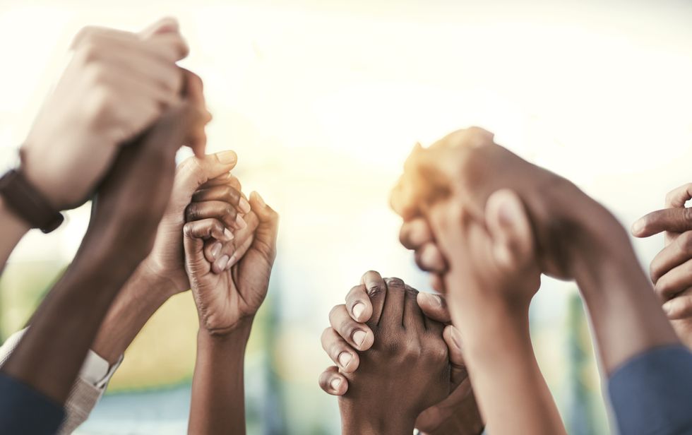 group of people holding their hands in solidarity