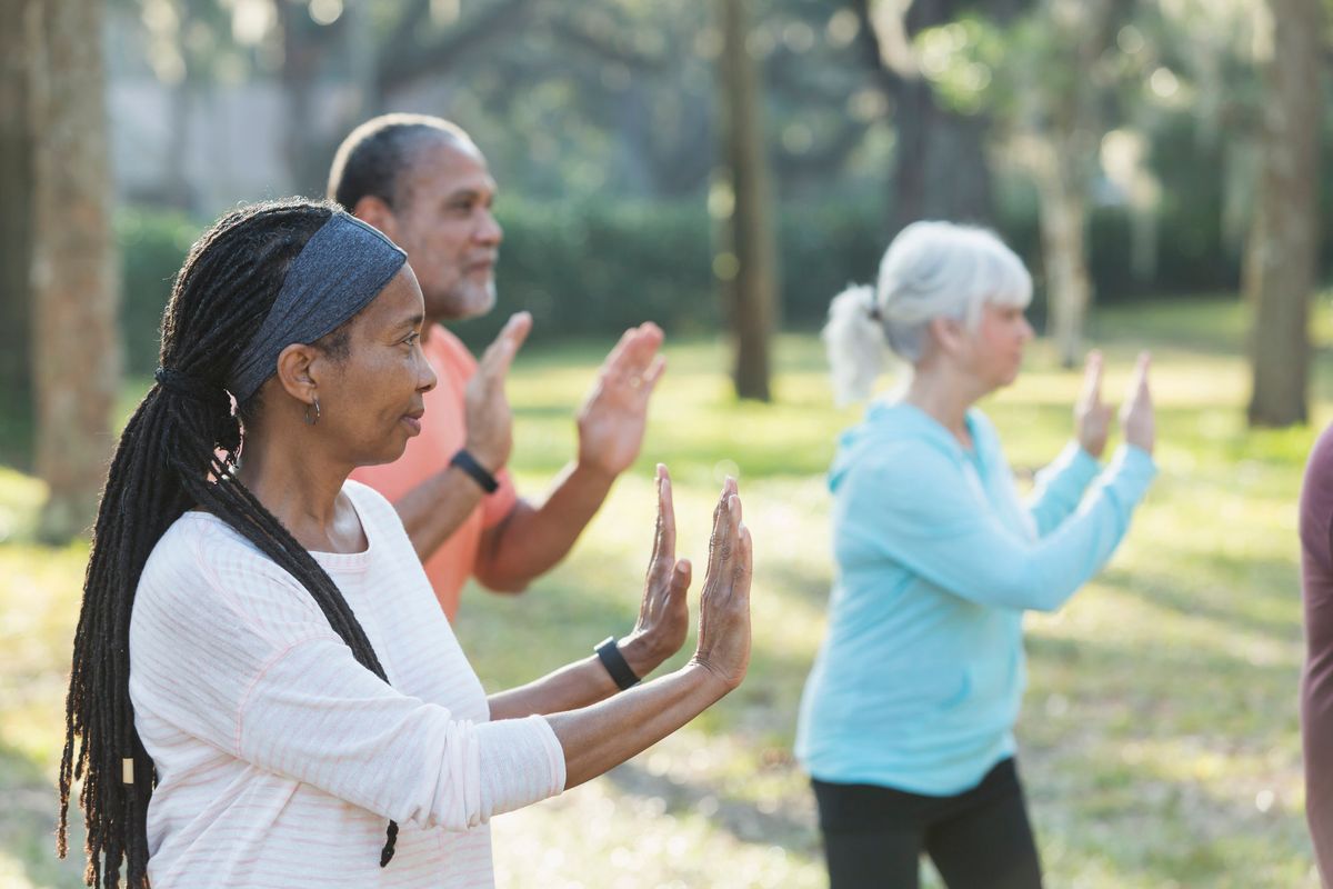 group of three multi-ethnic seniors taking an exercise class in the park