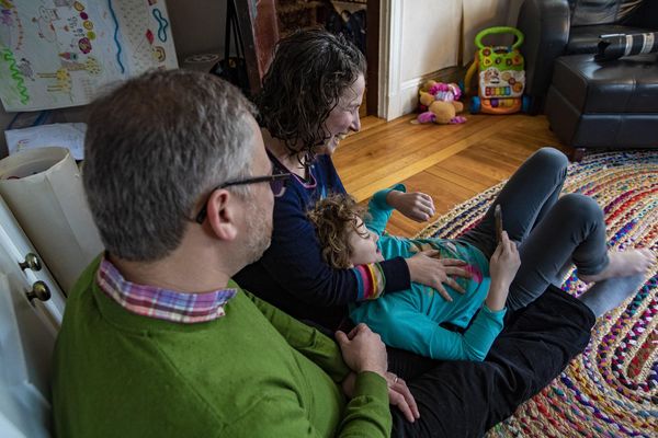  Hallel lies on Shira's lap during a family conversation in the living room.