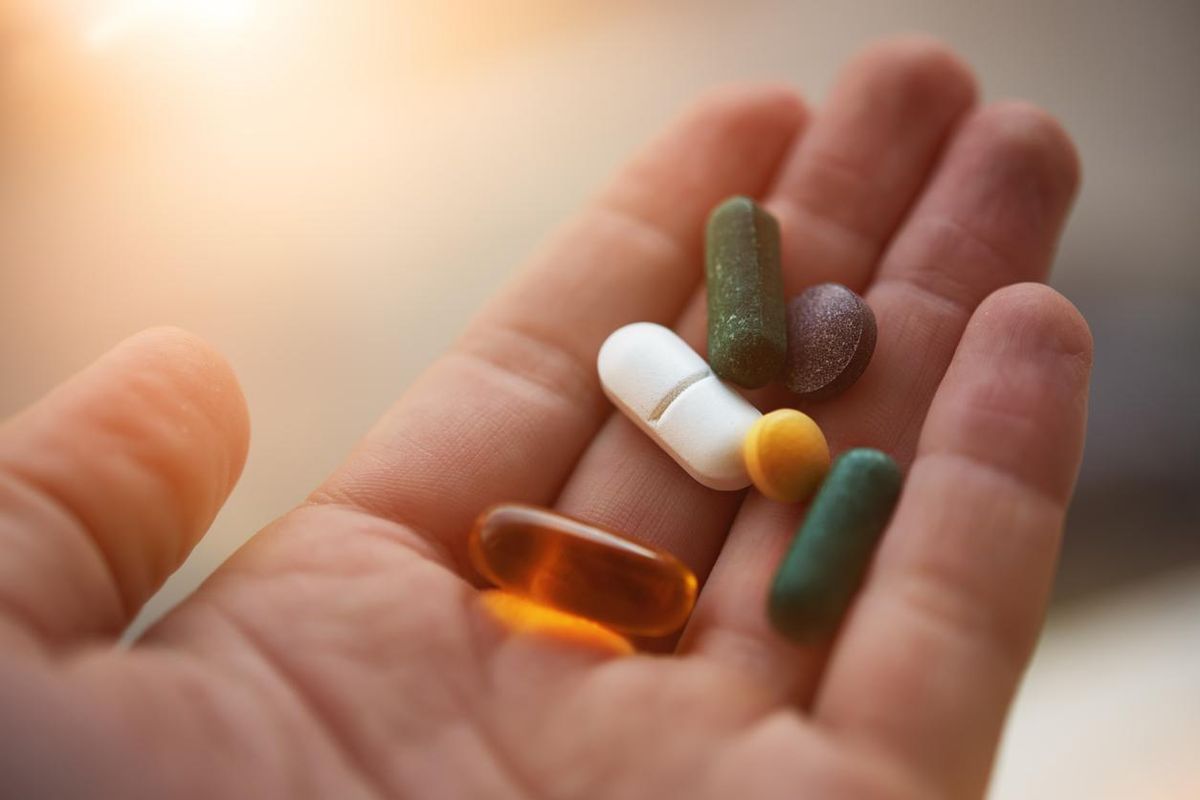 hand holding his nutritional supplemets