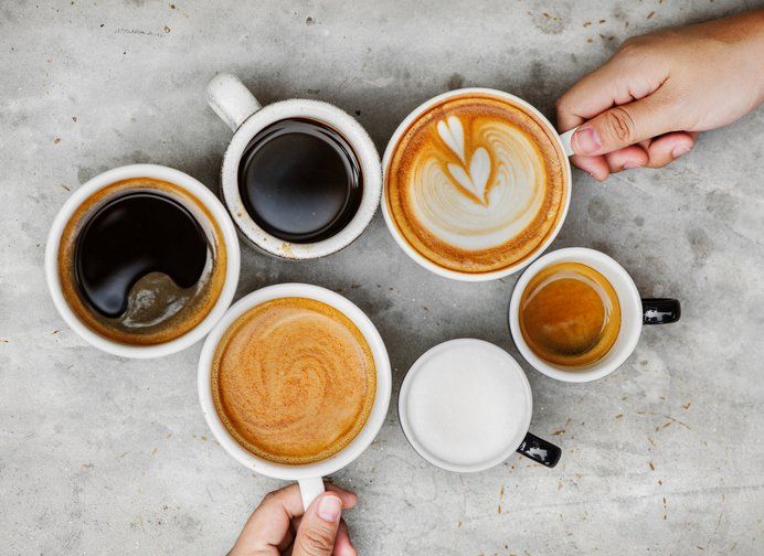 Hands Holding Coffee Cups On Table