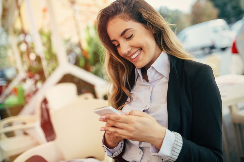 Happy businesswoman texting on her phone