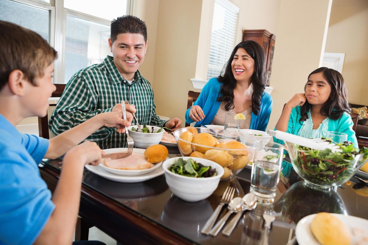 Happy Hispanic family enjoying dinner together