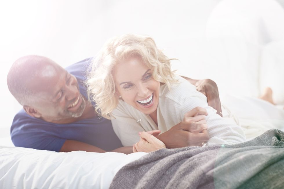 Happy mature couple lying on bed