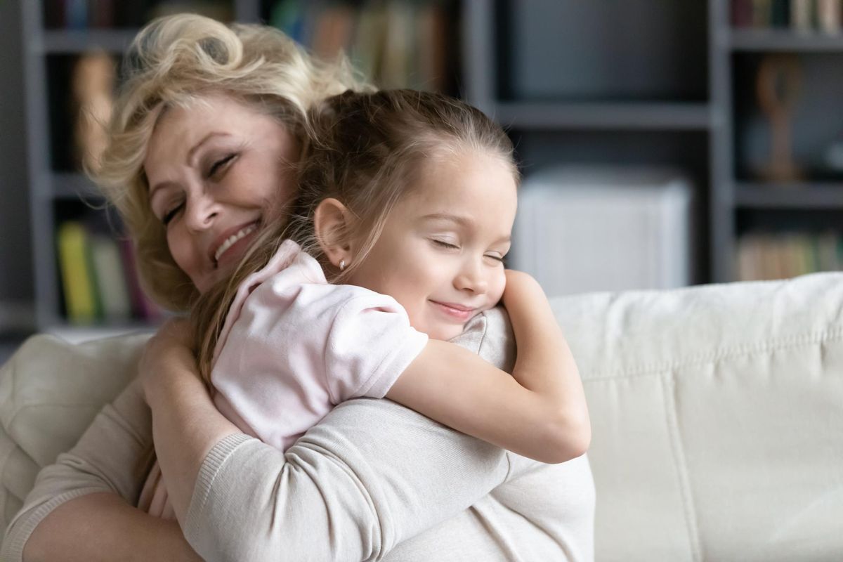 Happy senior granny cuddle with granddaughter